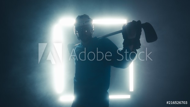 Image de Portrait of Caucasian male ice hockey player in uniform looking into the camera dramatic lighting